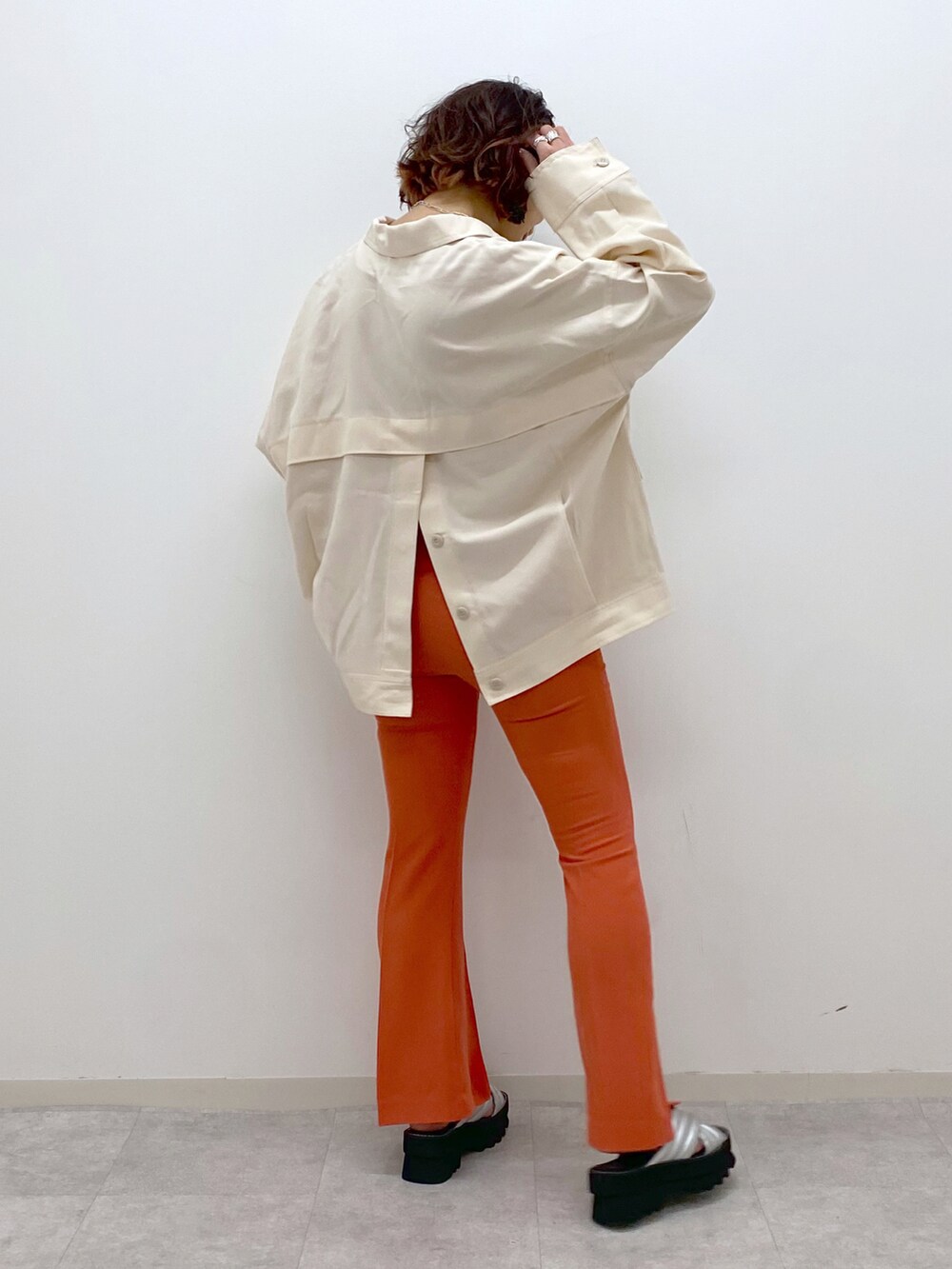 オレンジ系のその他パンツ、シルバー系のサンダル、ベージュ系のミリタリージャケットを着用したレディースの春コーディネートの3枚目の写真