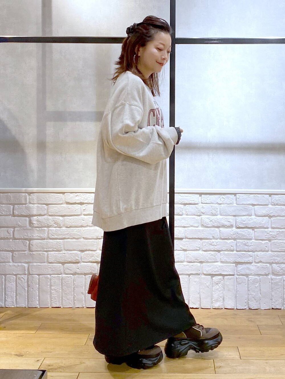 ブラウン系のブーツ、シルバー系のTシャツ/カットソー、ベージュ系のスウェットを着用したレディースの冬コーディネートの7枚目の写真