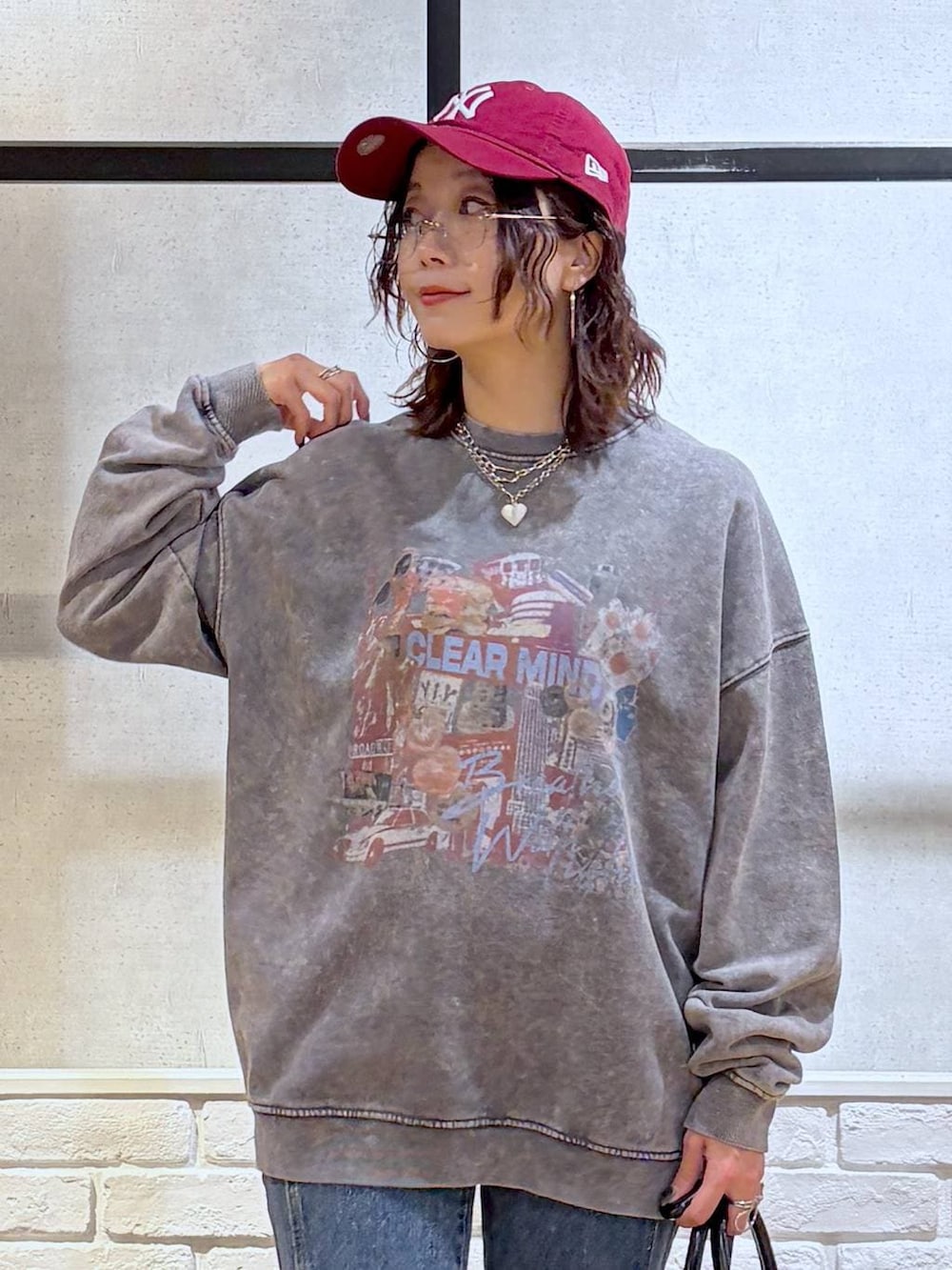 グレー系のスニーカー、ブルー系のデニムパンツ、ブラック系のショルダーバッグを着用したレディースの冬コーディネートの2枚目の写真