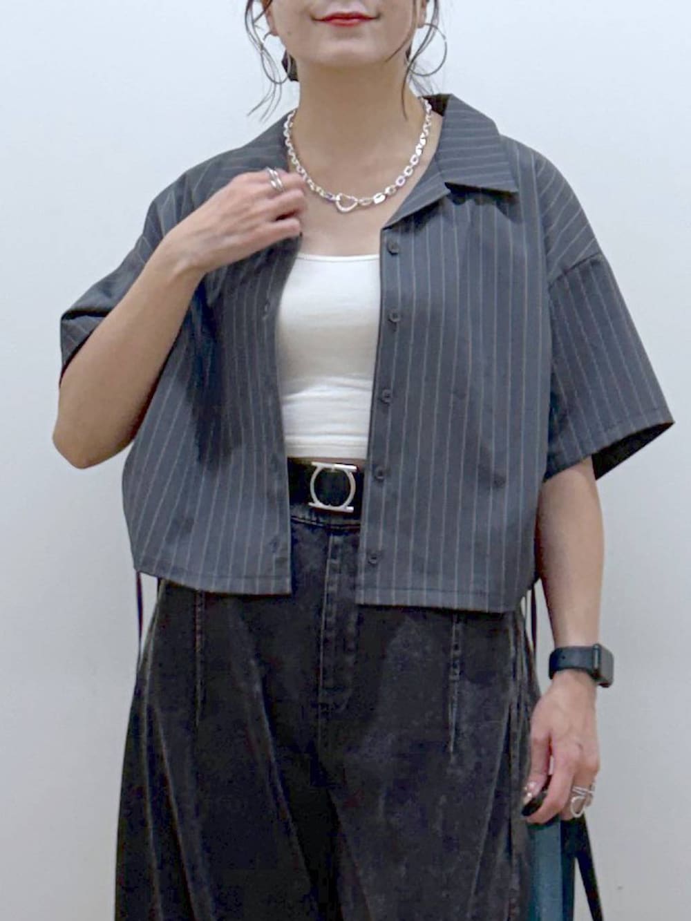 ブラック系のデニムパンツ、ブラック系のサンダル、グレー系のシャツ/ブラウスを着用したレディースの夏コーディネートの2枚目の写真