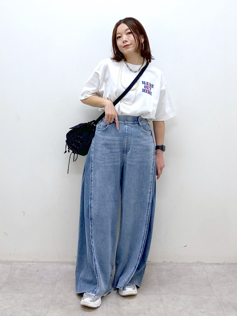 ホワイト系のTシャツ/カットソー、ブラック系のボディバッグ/ウエストポーチ、ブルー系のデニムパンツを着用したレディースの春コーディネートの4枚目の写真