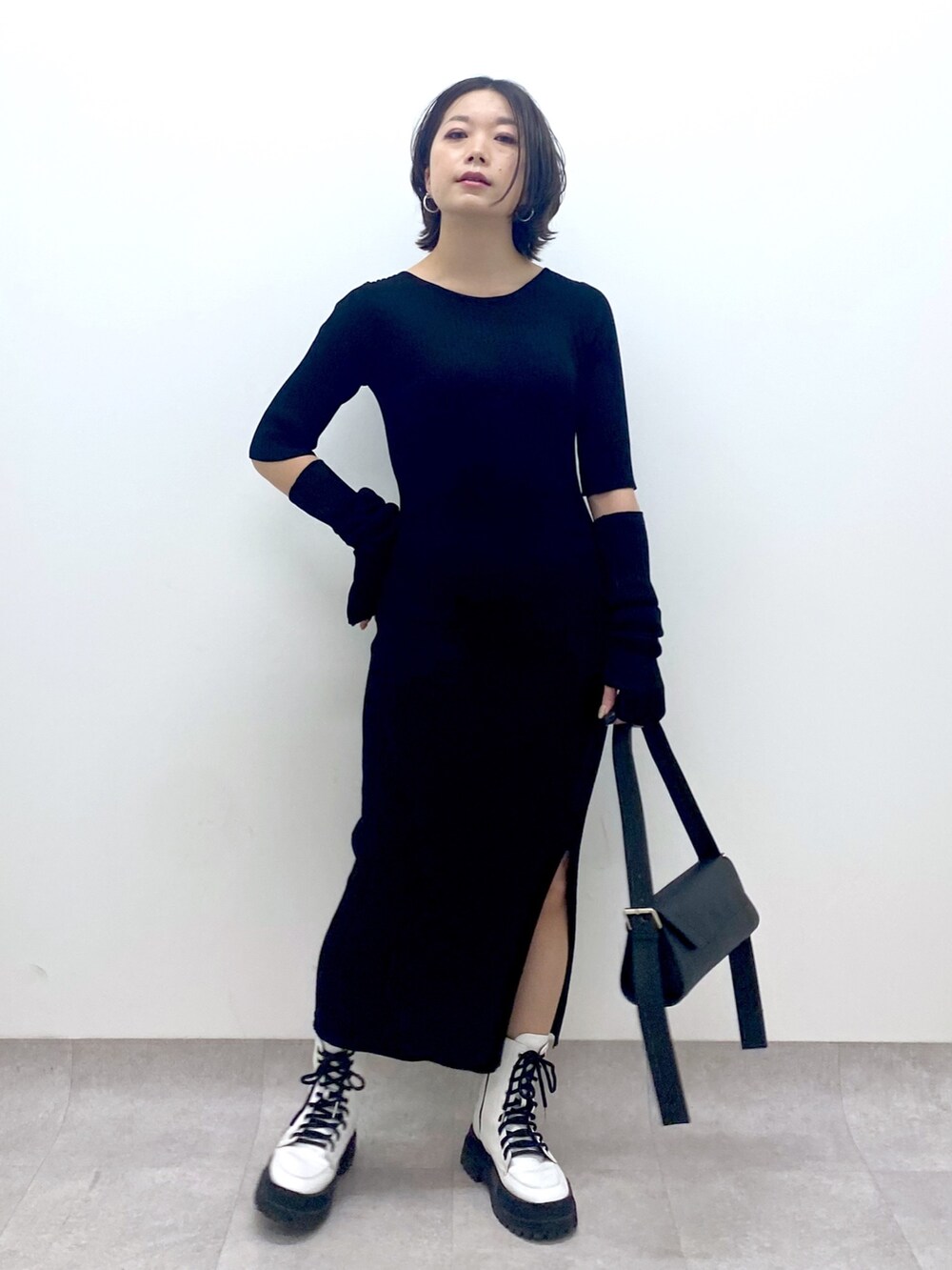 ブラック系のワンピース/ドレス、パープル系のトップス、ホワイト系のシューズを着用したレディースの春コーディネートの2枚目の写真