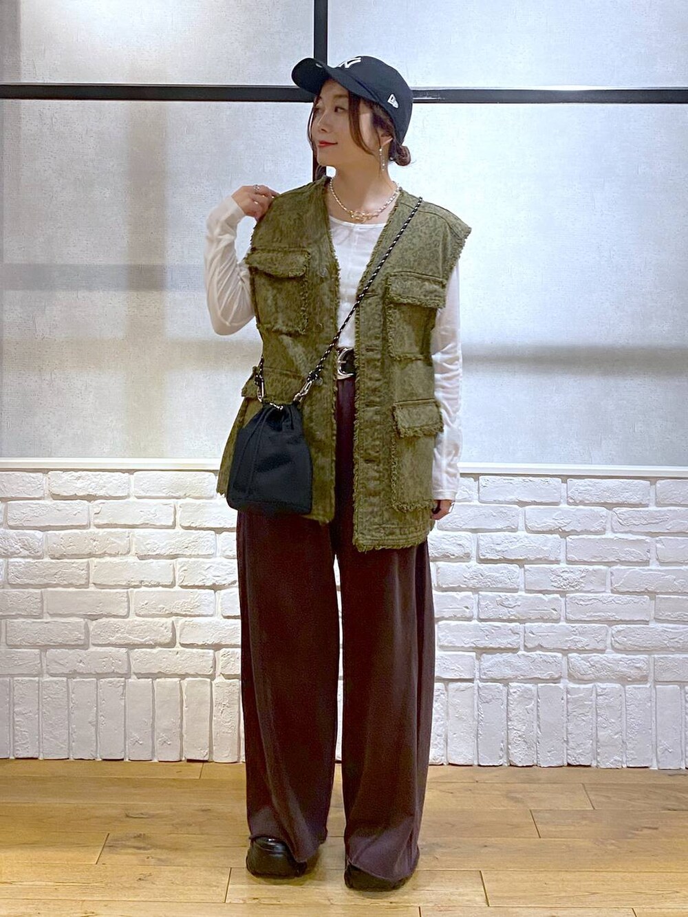 ブラック系のスニーカー、ブラウン系のスウェットパンツ、ブラック系のショルダーバッグを着用したレディースの夏コーディネートの4枚目の写真