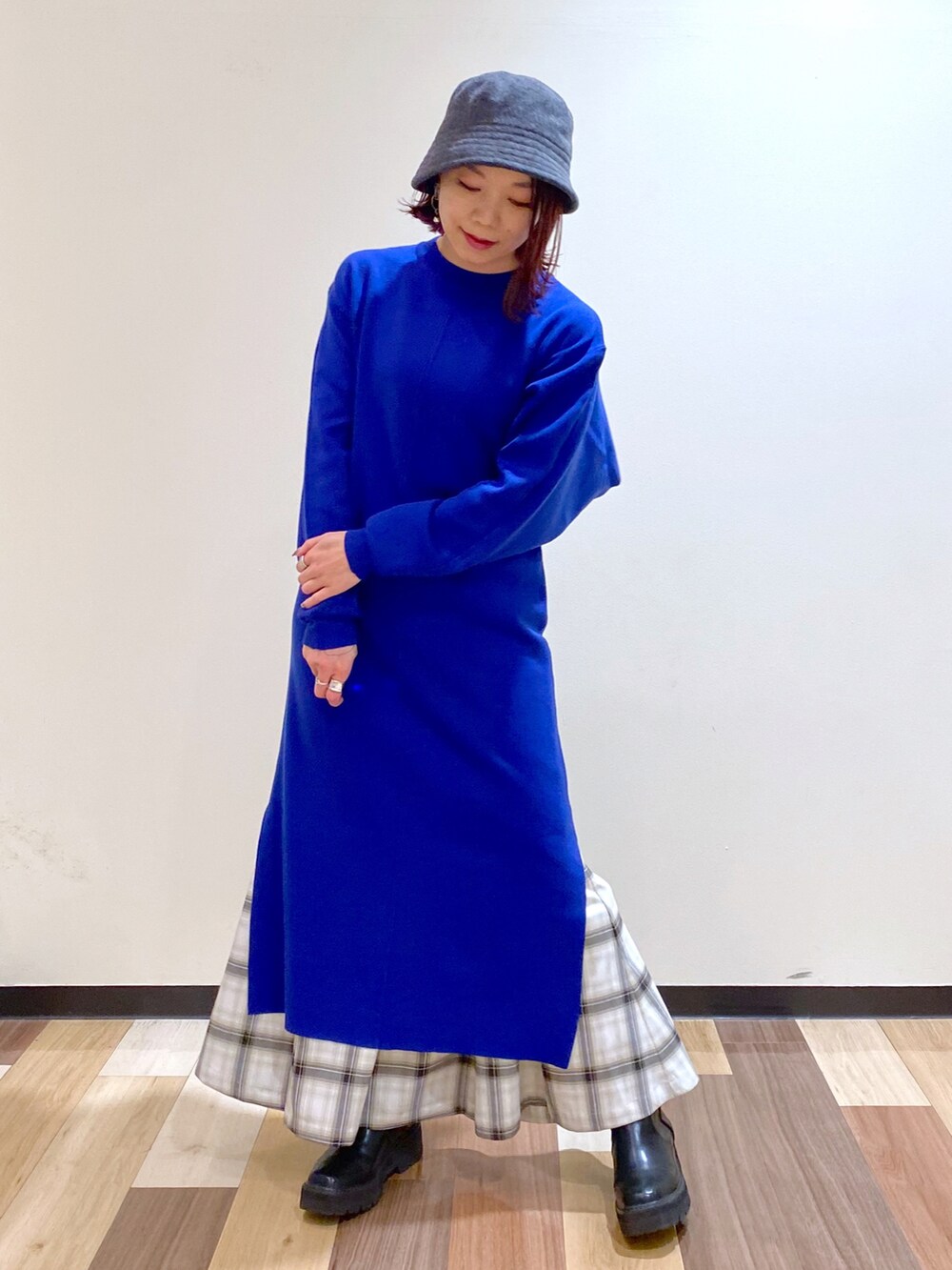 ブルー系のワンピース、ブラック系のブーツ、ホワイト系のスカートを着用したレディースの冬コーディネートの2枚目の写真