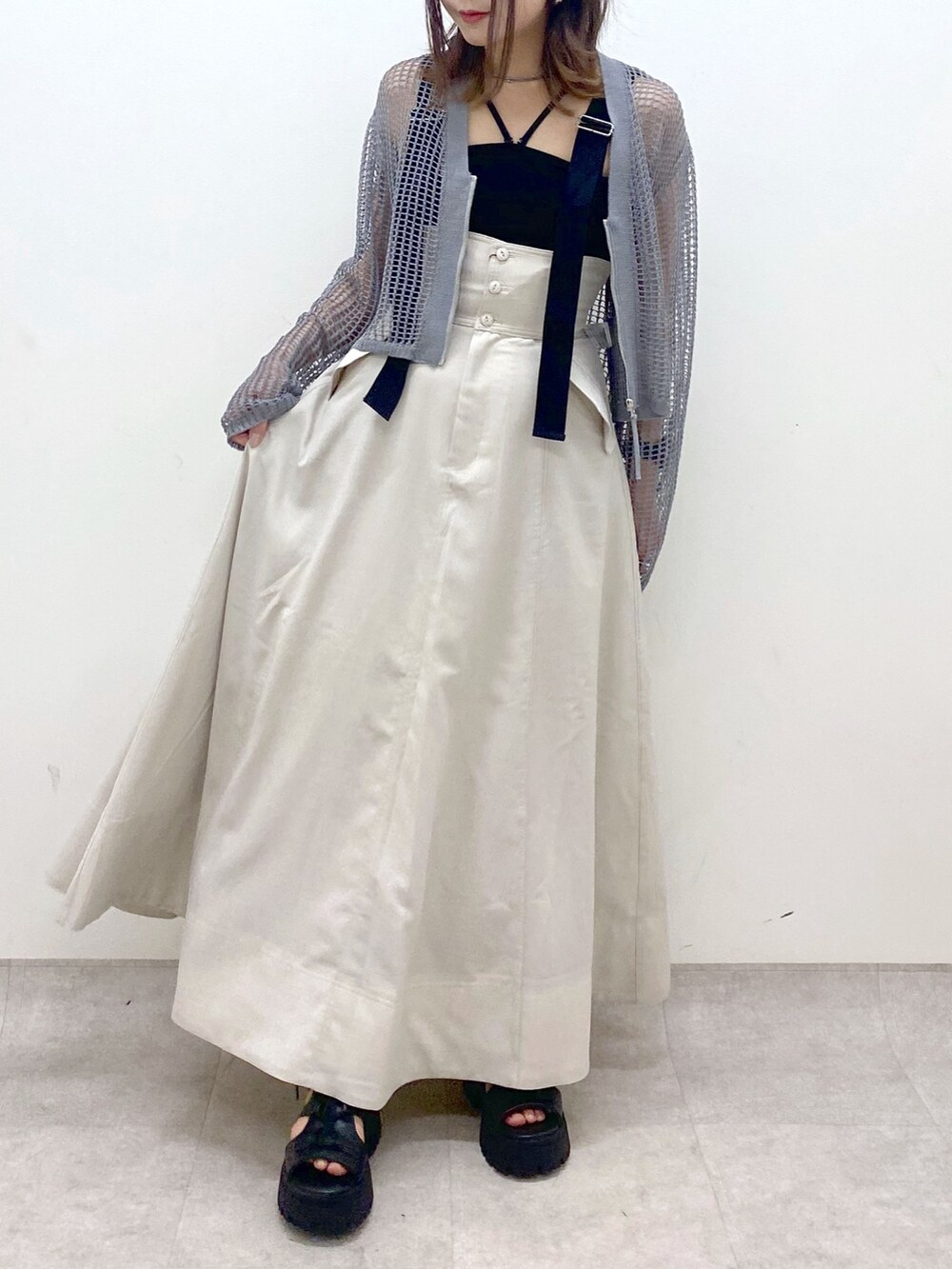 ブラック系のキャミソール、グレー系のカーディガン/ボレロ、ベージュ系のスカートを着用したレディースの春コーディネートの3枚目の写真