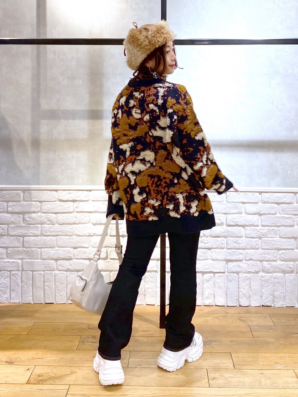 ブルー系のニット/セーター、ブルー系のデニムパンツ、ホワイト系のショルダーバッグを着用したレディースの冬コーディネートの6枚目の写真