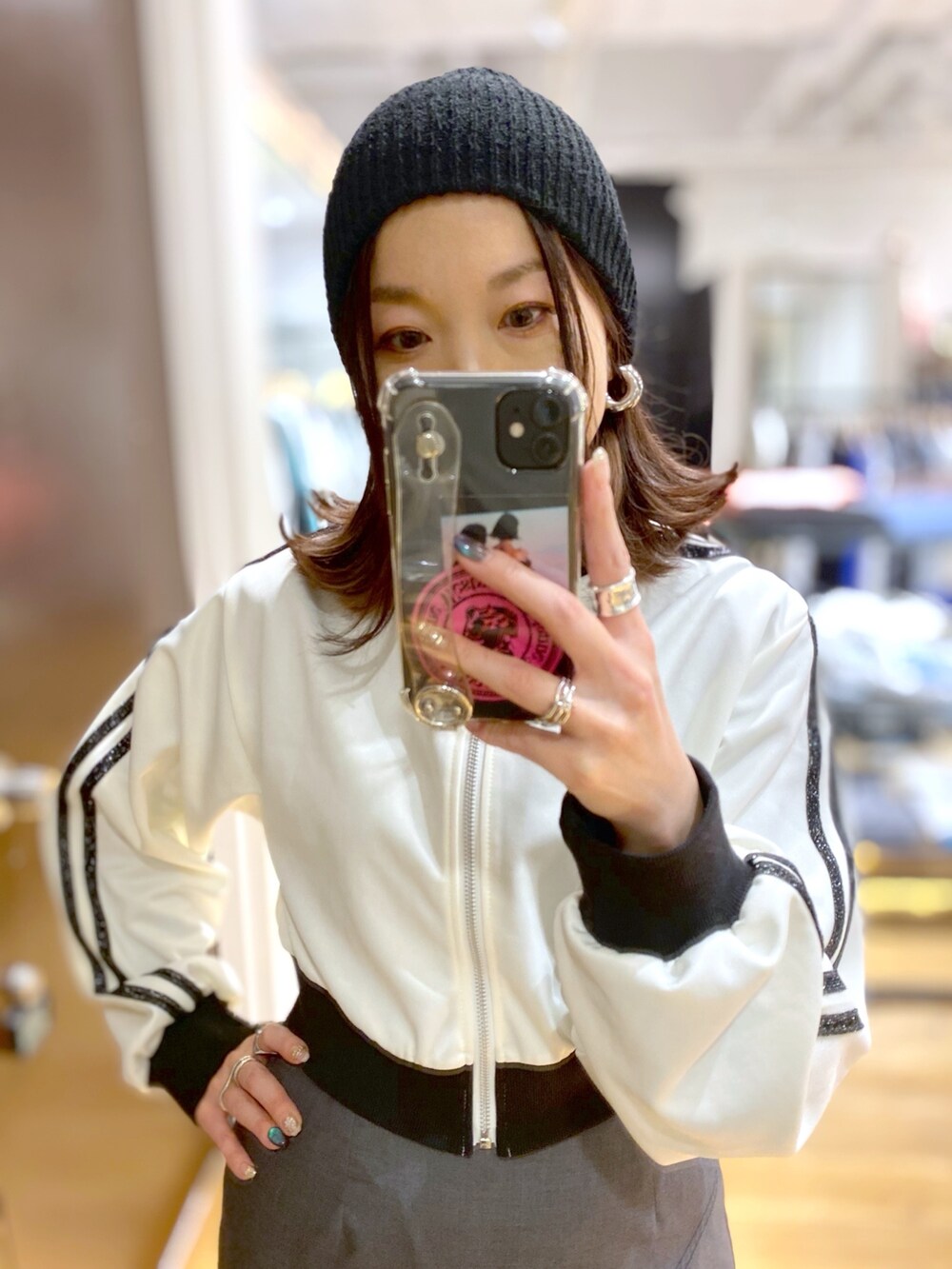 グレー系のスカート、ホワイト系のジャージ、ブラック系のブーツを着用したレディースの冬コーディネートの3枚目の写真