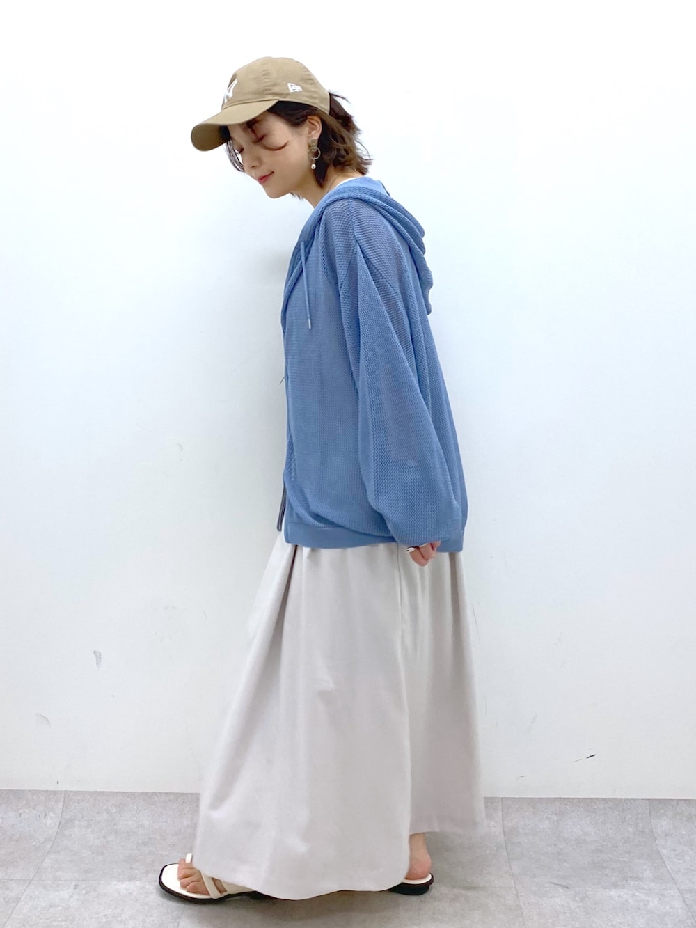 ベージュ系のジャンパースカート、ブルー系のニット/セーター、ブラック系のキャミソールを着用したレディースの夏コーディネートの4枚目の写真