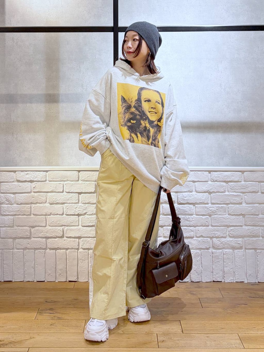 ホワイト系のスニーカー、イエロー系のスウェットパンツ、ブラウン系のショルダーバッグを着用したレディースの春コーディネートの4枚目の写真