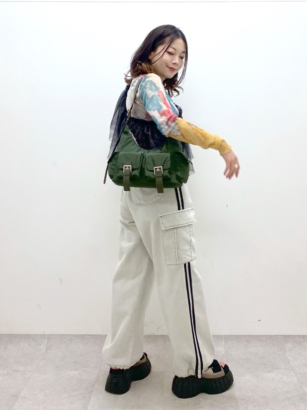 グリーン系のショルダーバッグ、その他のスニーカー、ホワイト系のデニムパンツを着用したレディースの春コーディネートの6枚目の写真
