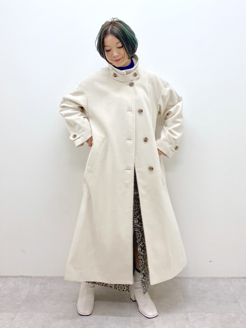 ブルー系のトップス、ホワイト系のジャケット/アウター、ブラック系のスカートを着用したレディースの秋コーディネートの5枚目の写真