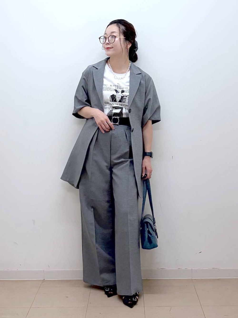 ホワイト系のTシャツ/カットソー、グレー系のスラックス、ブラック系のサンダルを着用したレディースの夏コーディネートの9枚目の写真