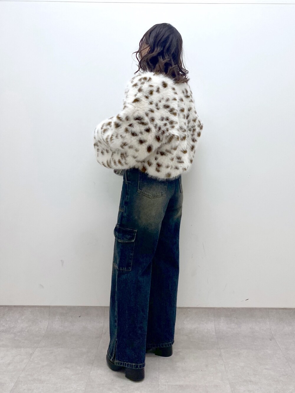 ブルー系のデニムパンツ、ブルー系のニット/セーター、ブラック系のブーツを着用したレディースの冬コーディネートの3枚目の写真