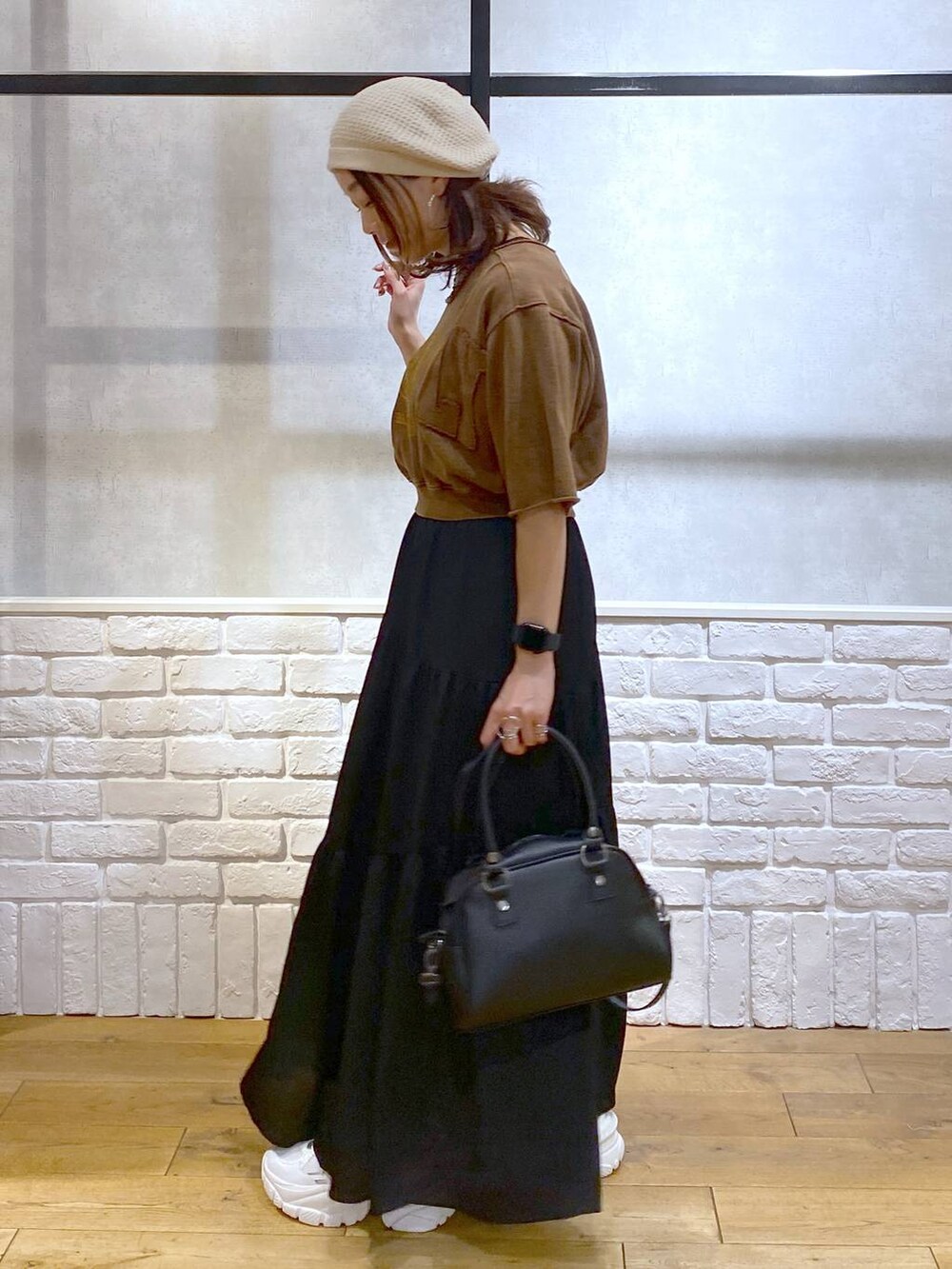 ブラウン系のタンクトップ、ブラック系のショルダーバッグ、ホワイト系のスニーカーを着用したレディースの夏コーディネートの5枚目の写真