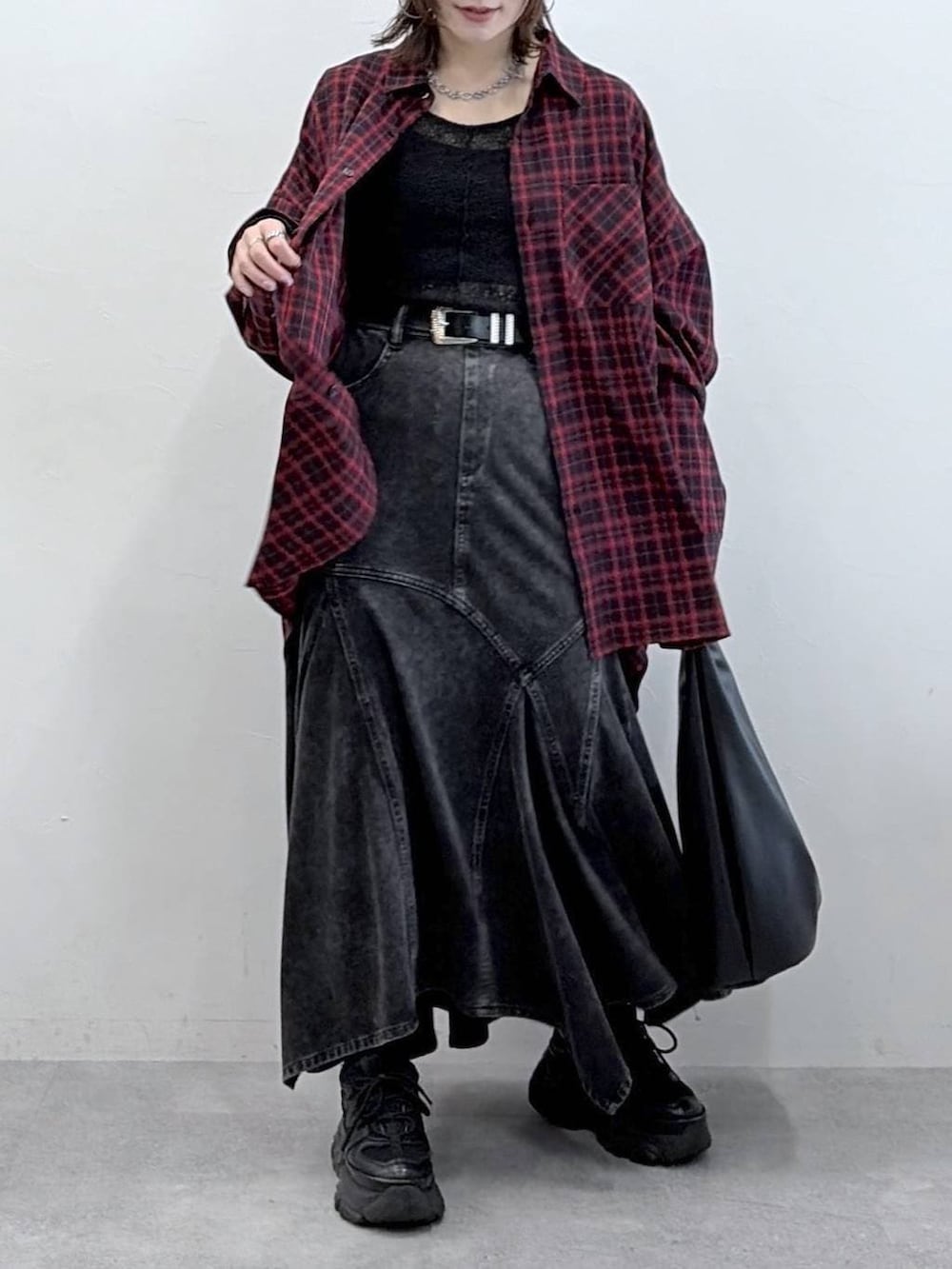 ブラック系のスニーカー、ブラック系のデニムスカート、ブラック系のトートバッグを着用したレディースの春コーディネートの3枚目の写真