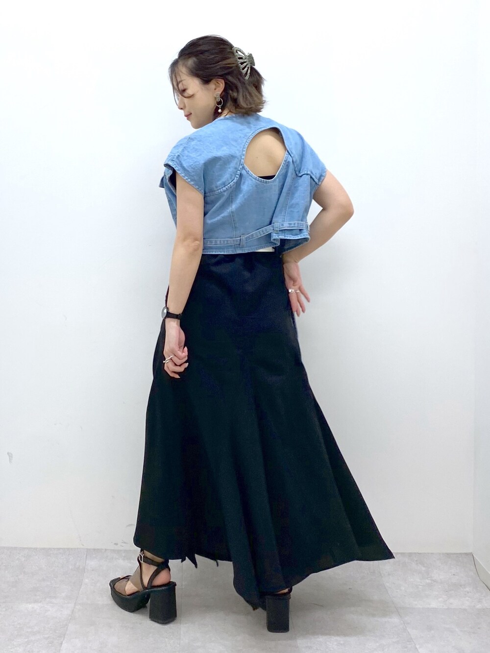 ブラック系のスカート、ブルー系のその他アウター、その他のサンダルを着用したレディースの春コーディネートの4枚目の写真