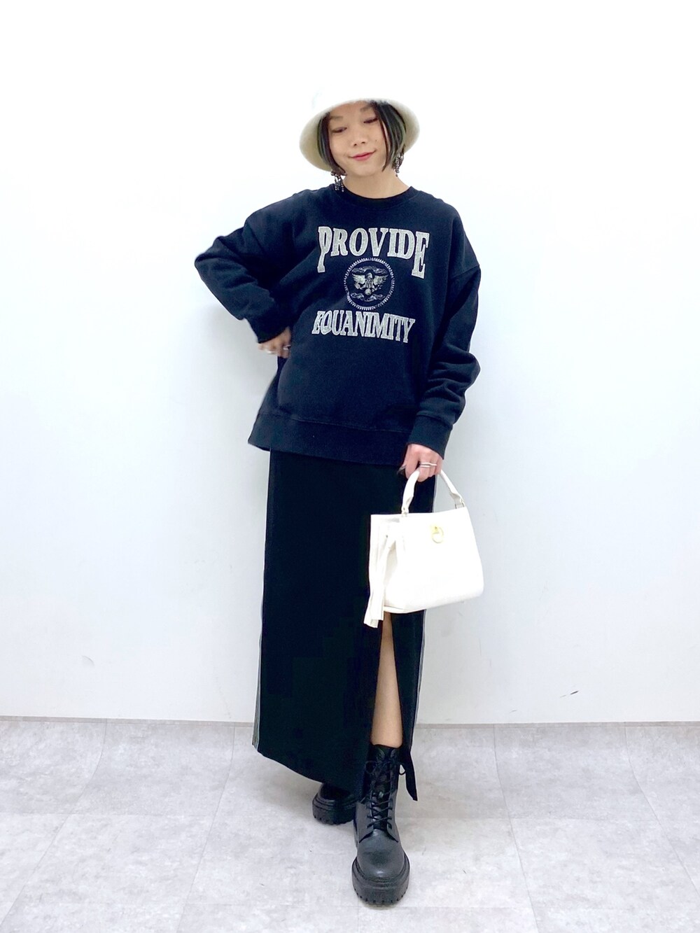 ブラック系のTシャツ/カットソー、ブラック系のスカート、ホワイト系のショルダーバッグを着用したレディースの冬コーディネートの5枚目の写真