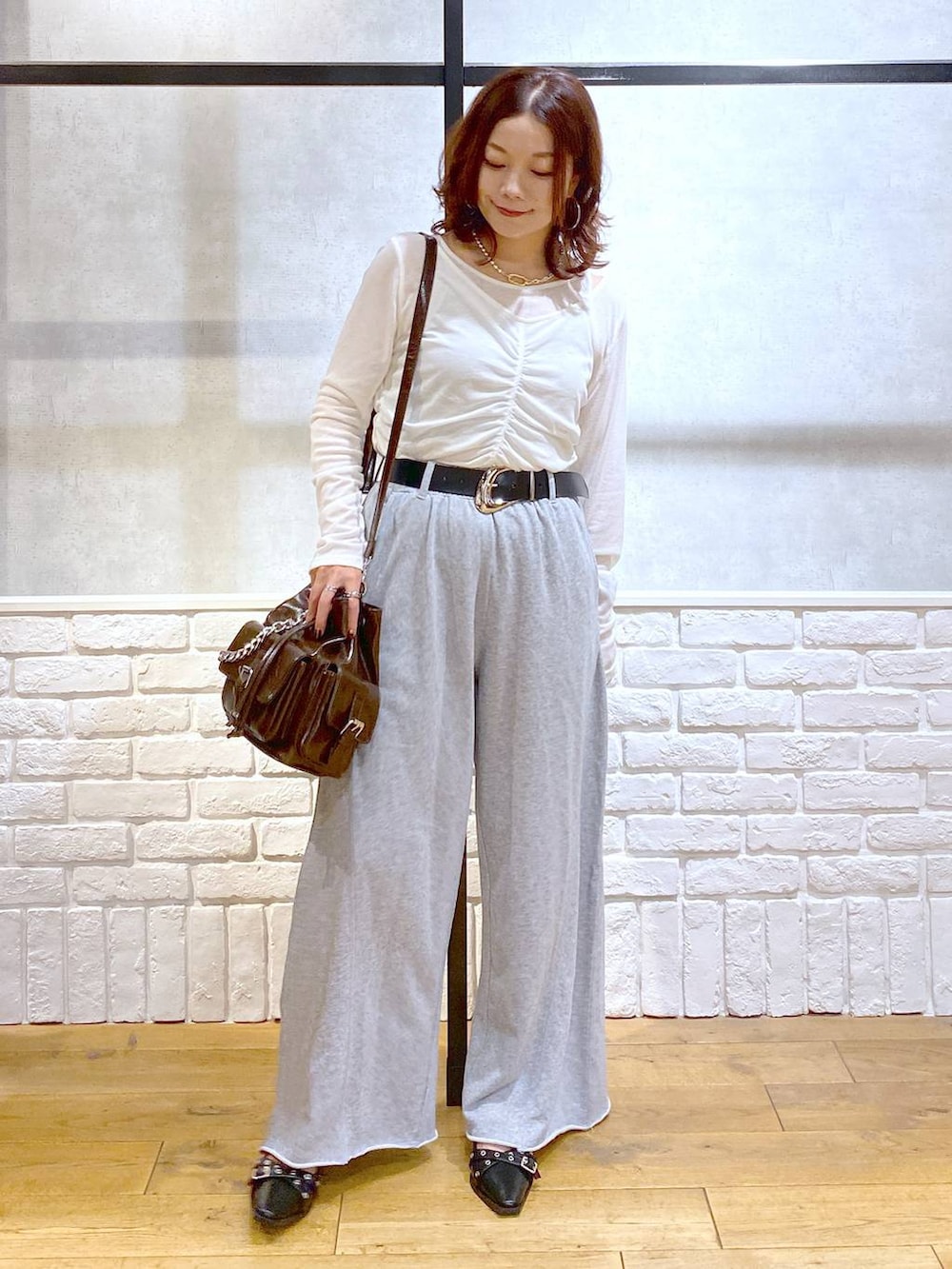 ブラック系のパンプス、グレー系のスウェットパンツ、ブラック系のハンドバッグを着用したレディースの秋コーディネートの4枚目の写真