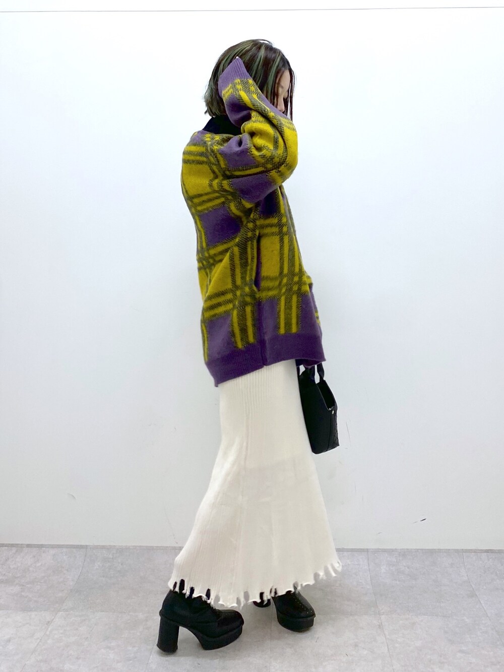 ホワイト系のトップス、ゴールド系のスカート、ブラック系のブーツを着用したレディースの冬コーディネートの4枚目の写真