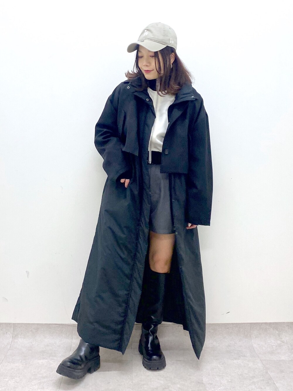 ブラック系のベスト、ブラック系のブーツ、ホワイト系のジャージを着用したレディースの秋コーディネートの3枚目の写真