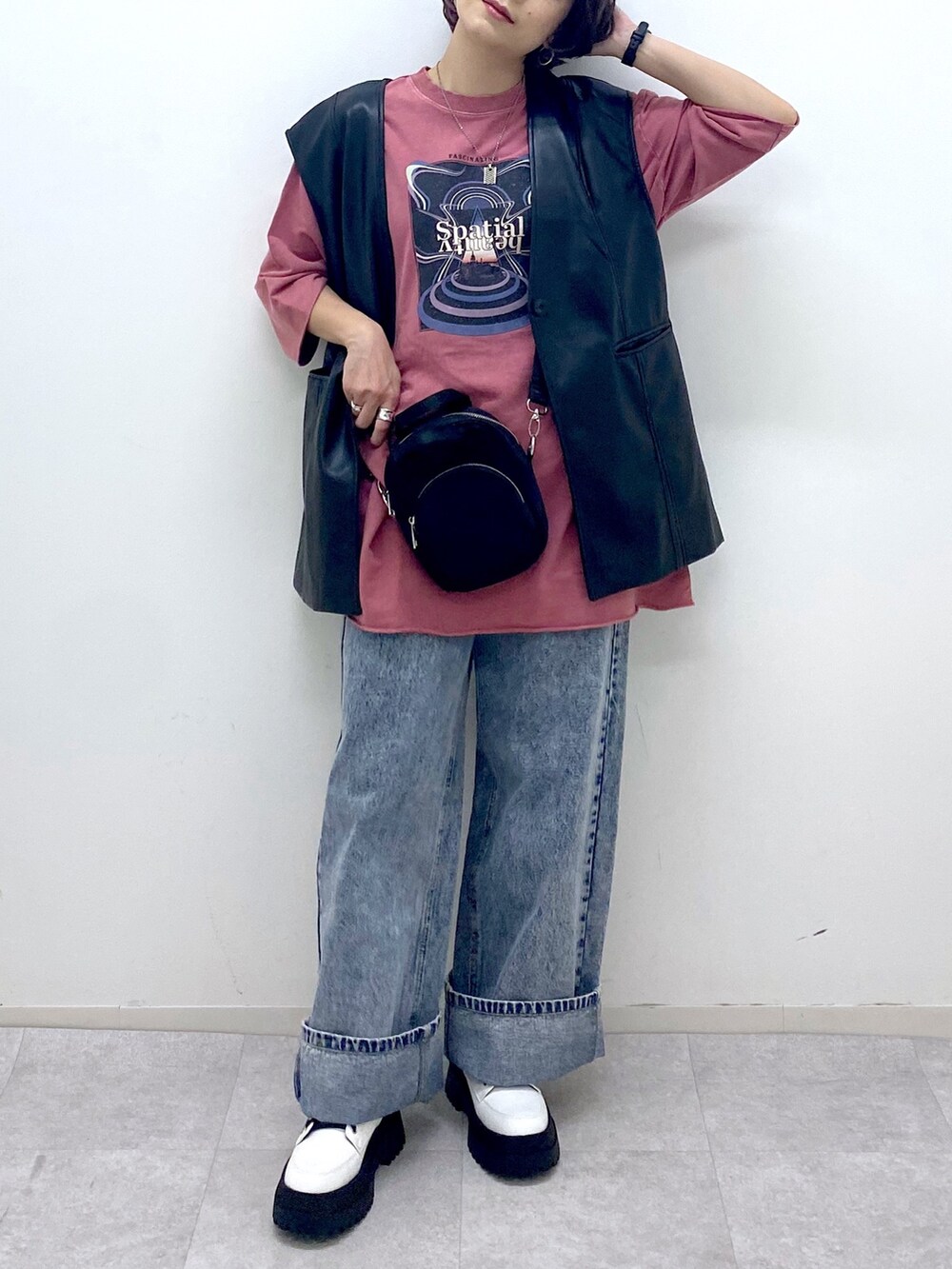 ブルー系のデニムパンツ、ホワイト系のブーツ、ブラック系のショルダーバッグを着用したレディースの秋コーディネートの4枚目の写真