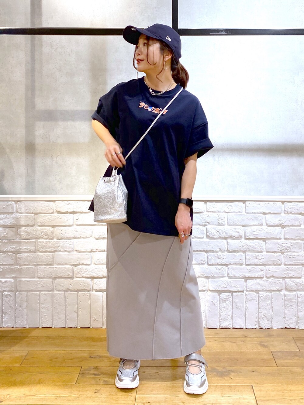 ブルー系のTシャツ/カットソー、グレー系のスカート、グレー系のスニーカーを着用したレディースの春コーディネートの4枚目の写真