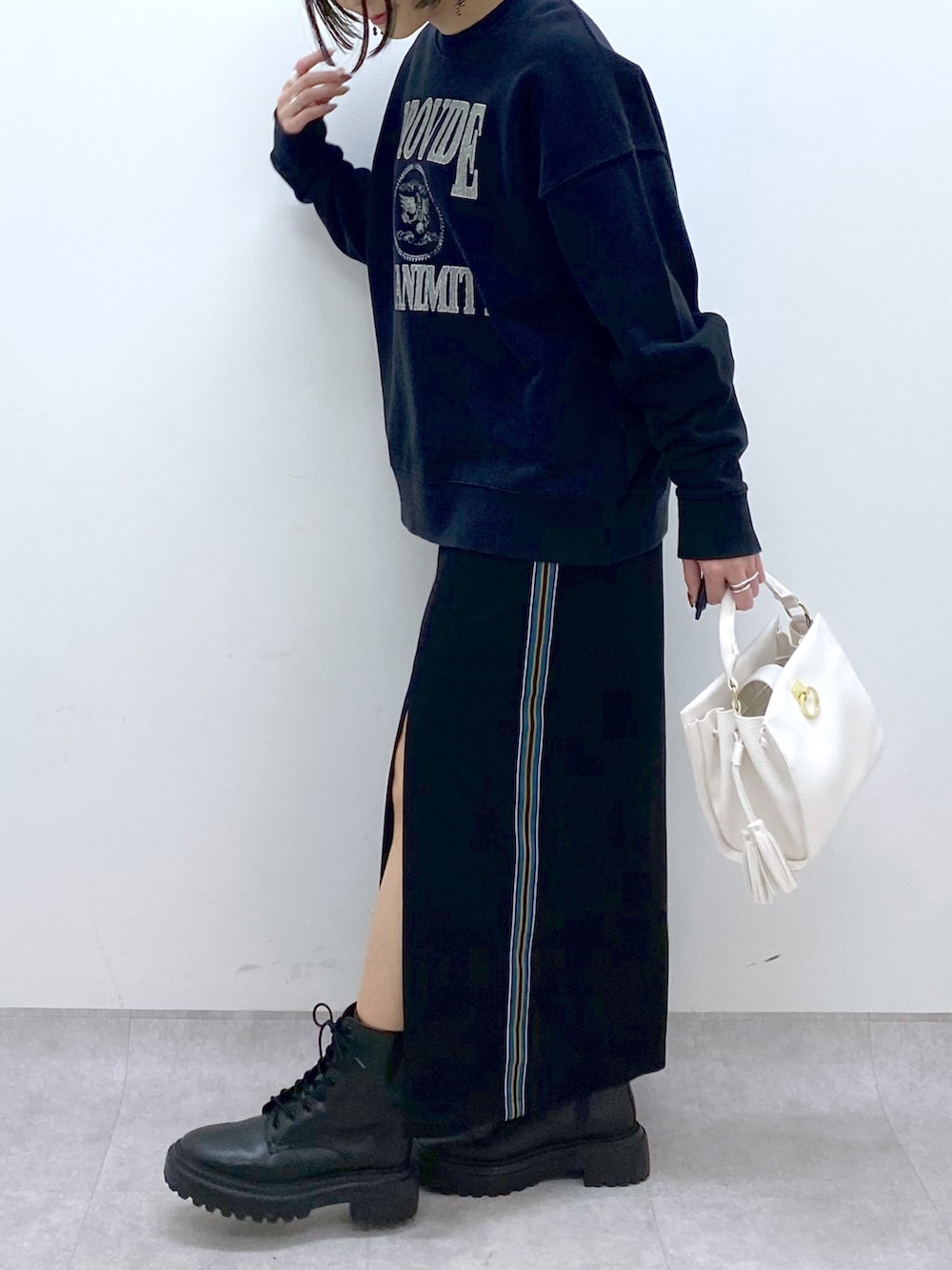 ブラック系のTシャツ/カットソー、ブラック系のスカート、ホワイト系のショルダーバッグを着用したレディースの冬コーディネートの4枚目の写真