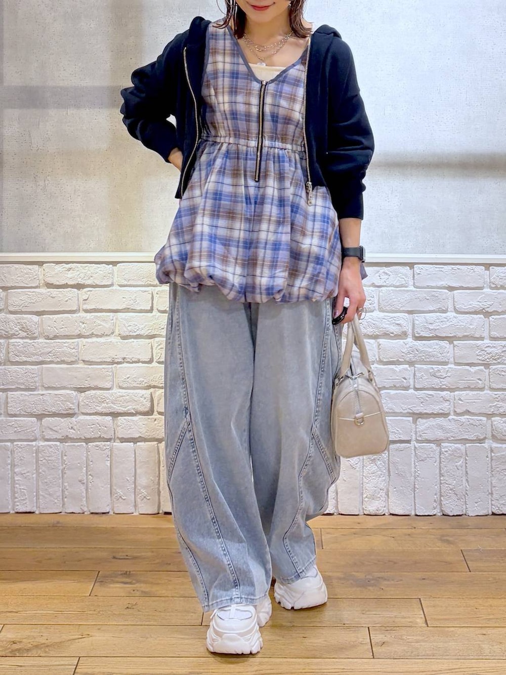 ホワイト系のスニーカー、ホワイト系のボストンバッグ、ブルー系のパーカーを着用したレディースの春コーディネートの3枚目の写真