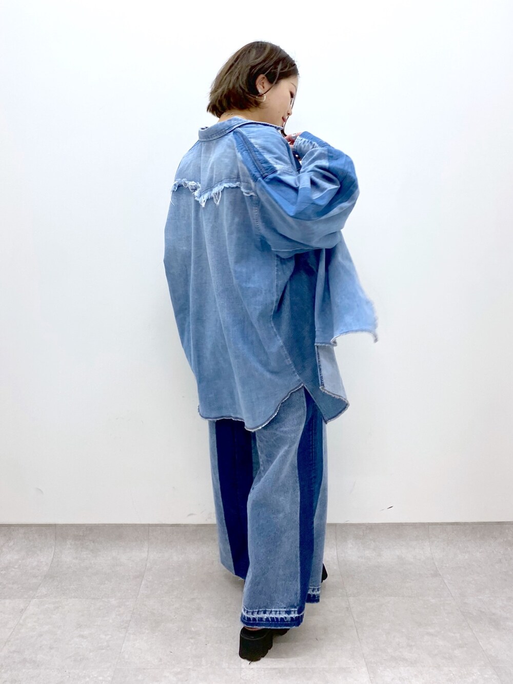 ブルー系のデニムパンツ、ブラック系のローファー、ブルー系のシャツ/ブラウスを着用したレディースの春コーディネートの2枚目の写真