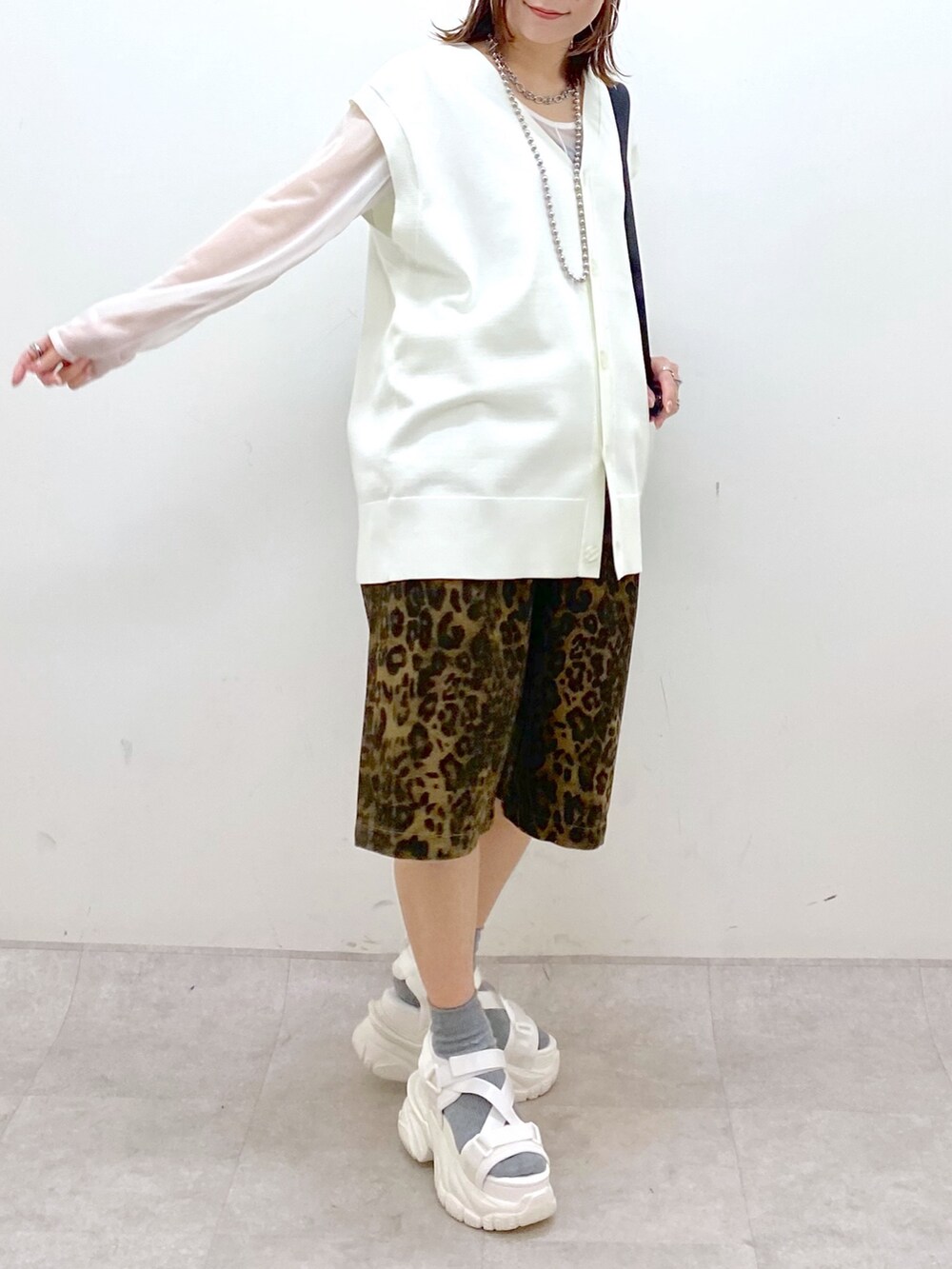 ホワイト系のカーディガン/ボレロ、ホワイト系のTシャツ/カットソー、ブラック系のバックパック/リュックを着用したレディースの春コーディネートの3枚目の写真