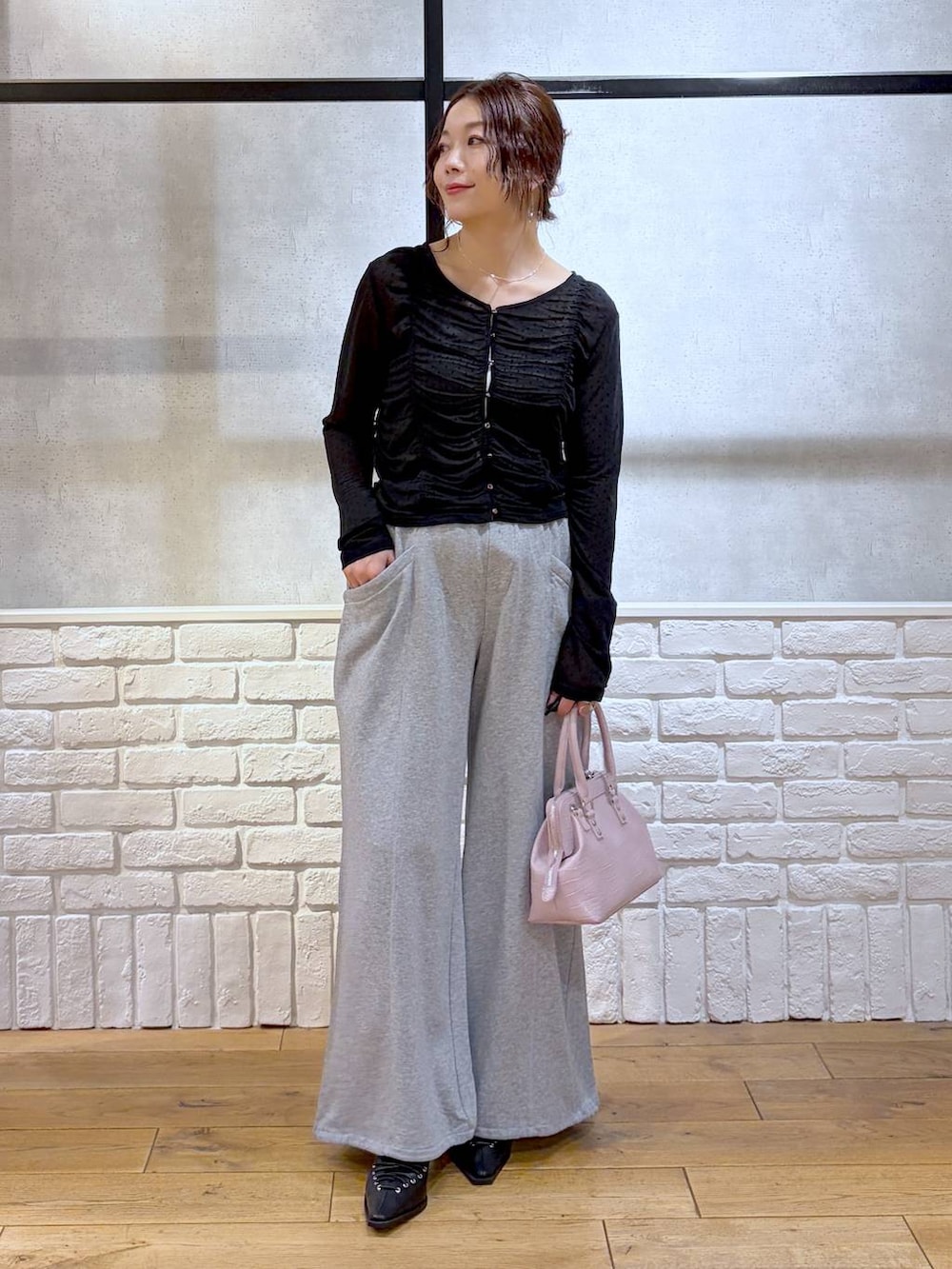 ホワイト系のキャミソール、ピンク系のハンドバッグ、グレー系のスウェットパンツを着用したレディースの春コーディネートの4枚目の写真
