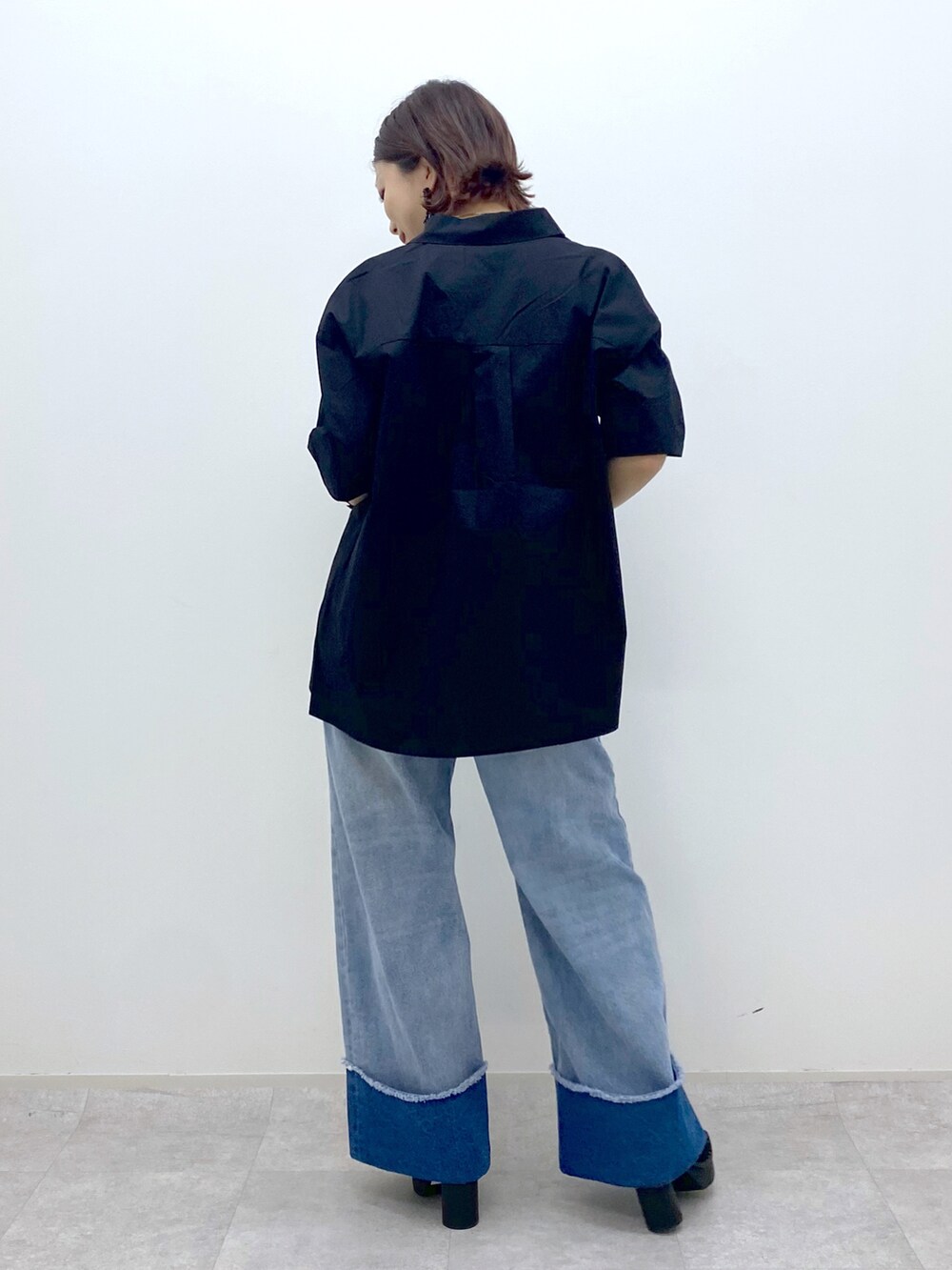 ブルー系のデニムパンツ、ブラック系のシャツ/ブラウス、ベージュ系のタンクトップを着用したレディースの春コーディネートの4枚目の写真