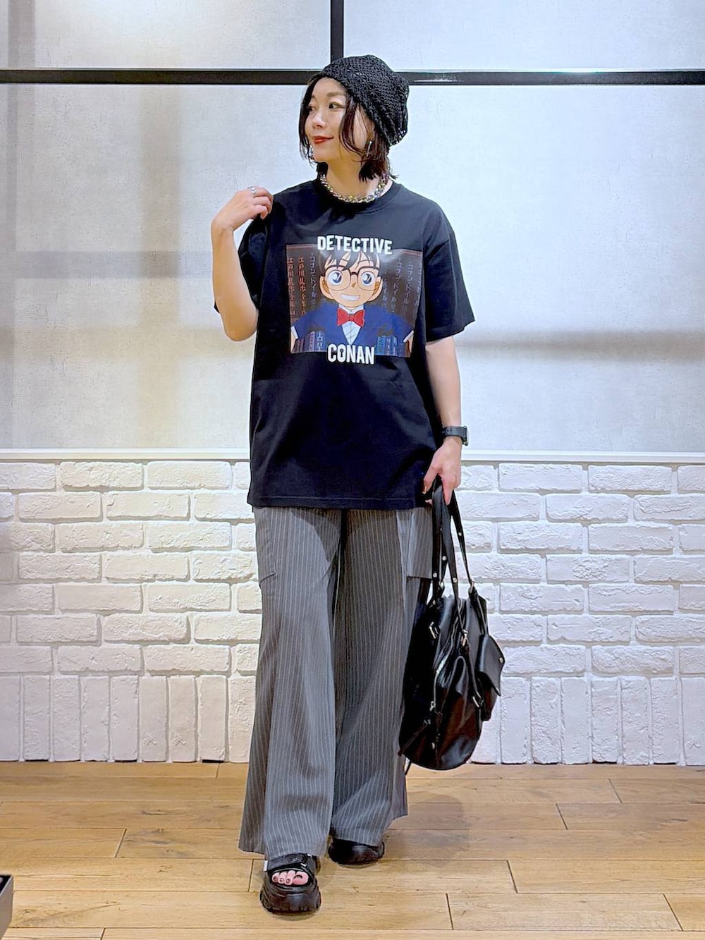ブラック系のサンダル、ブラック系のボストンバッグ、ブラック系のTシャツ/カットソーを着用したレディースの春コーディネートの4枚目の写真