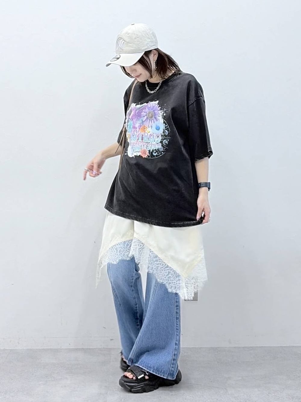 ブルー系のデニムパンツ、ブラウン系のボストンバッグ、ホワイト系のチュニックを着用したレディースの春コーディネートの8枚目の写真