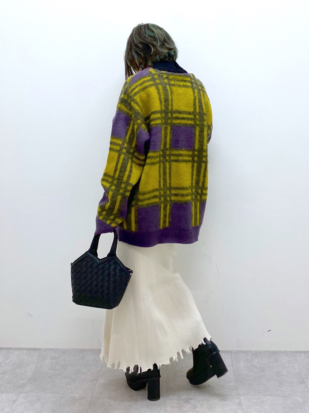 ホワイト系のトップス、ゴールド系のスカート、ブラック系のブーツを着用したレディースの冬コーディネートの3枚目の写真