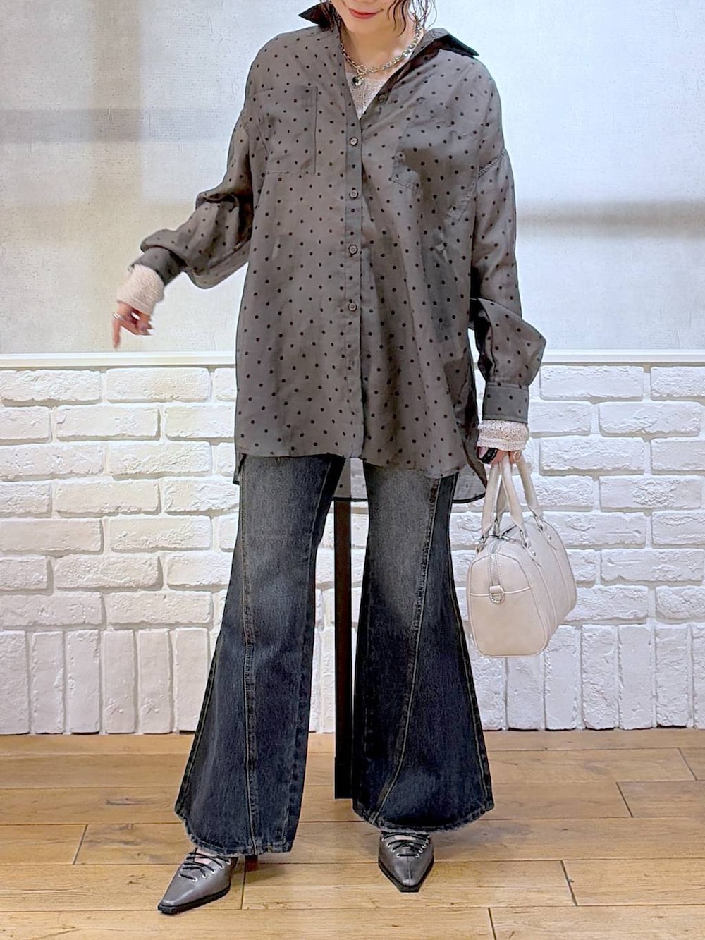 ブルー系のデニムパンツ、ホワイト系のボストンバッグ、ブラウン系のサンダルを着用したレディースの春コーディネートの2枚目の写真