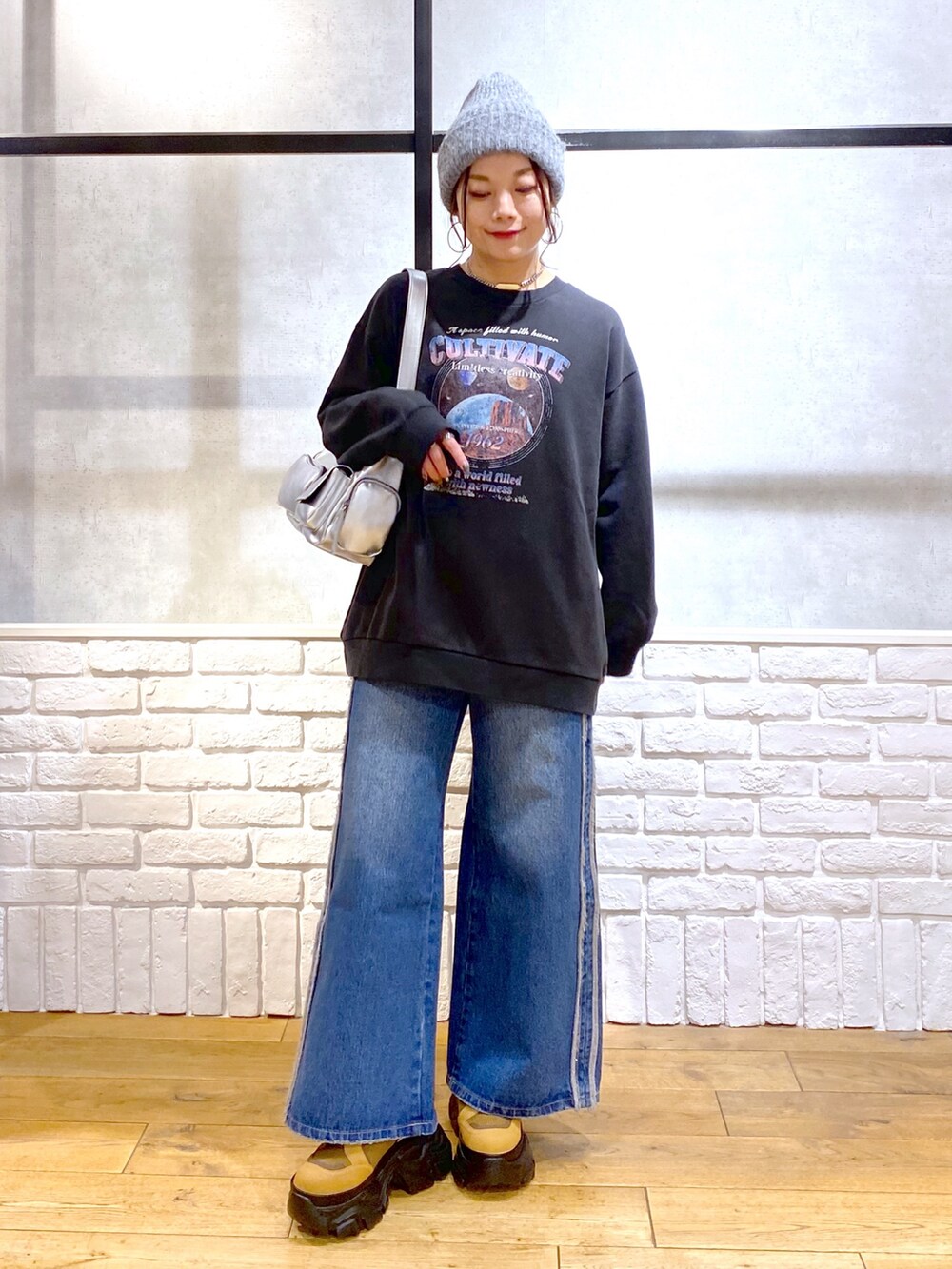 グレー系のスウェット、ブルー系のデニムパンツ、ブラウン系のブーツを着用したレディースの冬コーディネートの9枚目の写真