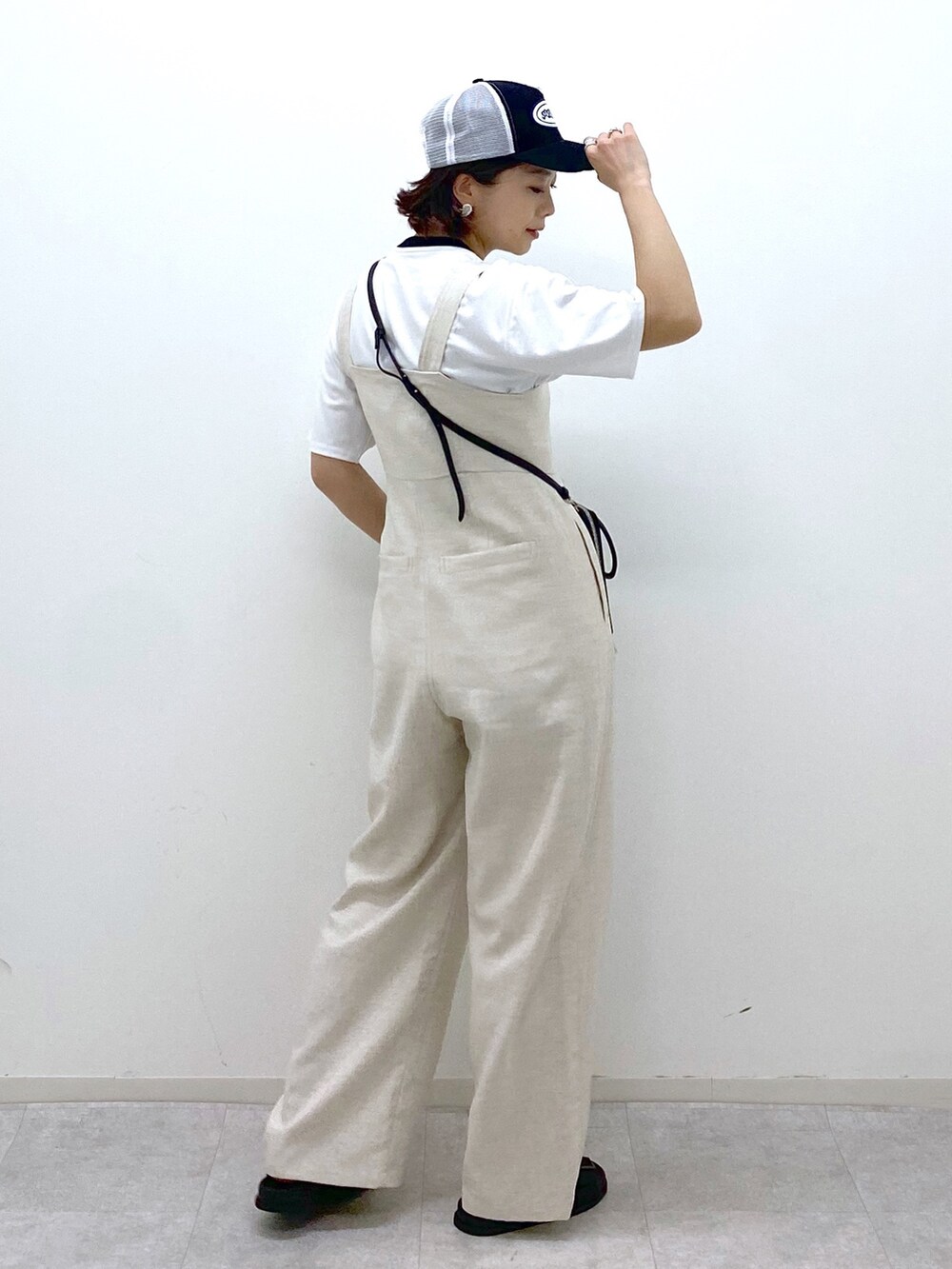 ホワイト系のサロペット/オーバーオール、ブラック系のサンダル、ホワイト系のTシャツ/カットソーを着用したレディースの夏コーディネートの3枚目の写真