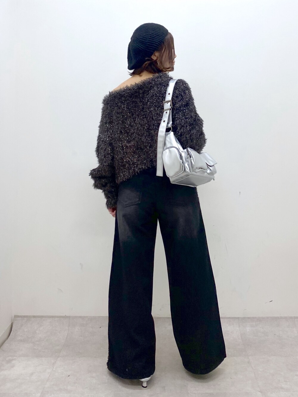 ブラック系のデニムパンツ、シルバー系のパンプス、シルバー系のショルダーバッグを着用したレディースの秋コーディネートの6枚目の写真