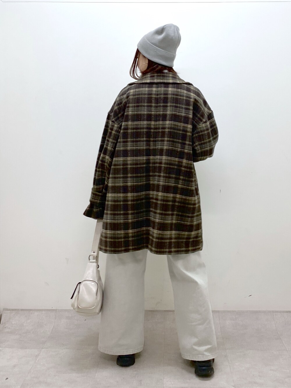 ブラウン系のテーラードジャケット、グレー系のデニムパンツ、ホワイト系のショルダーバッグを着用したレディースの冬コーディネートの6枚目の写真