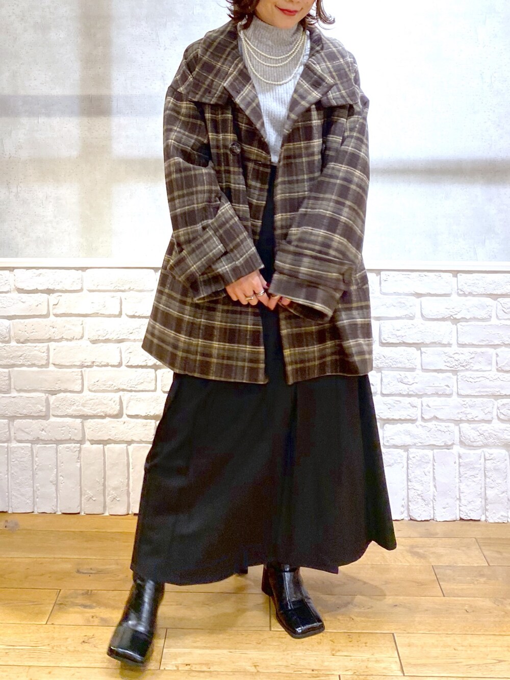 ブラウン系のテーラードジャケット、グレー系のTシャツ/カットソー、ブラック系のスカートを着用したレディースの冬コーディネートの2枚目の写真
