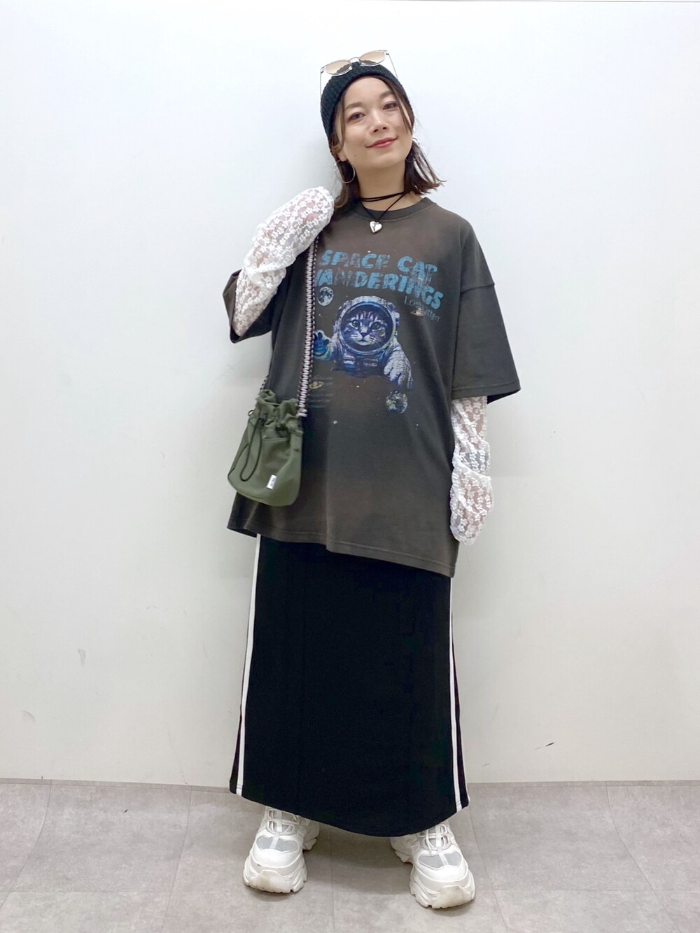 グレー系のTシャツ/カットソー、ブラック系のスカート、ホワイト系のスニーカーを着用したレディースの夏コーディネートの9枚目の写真