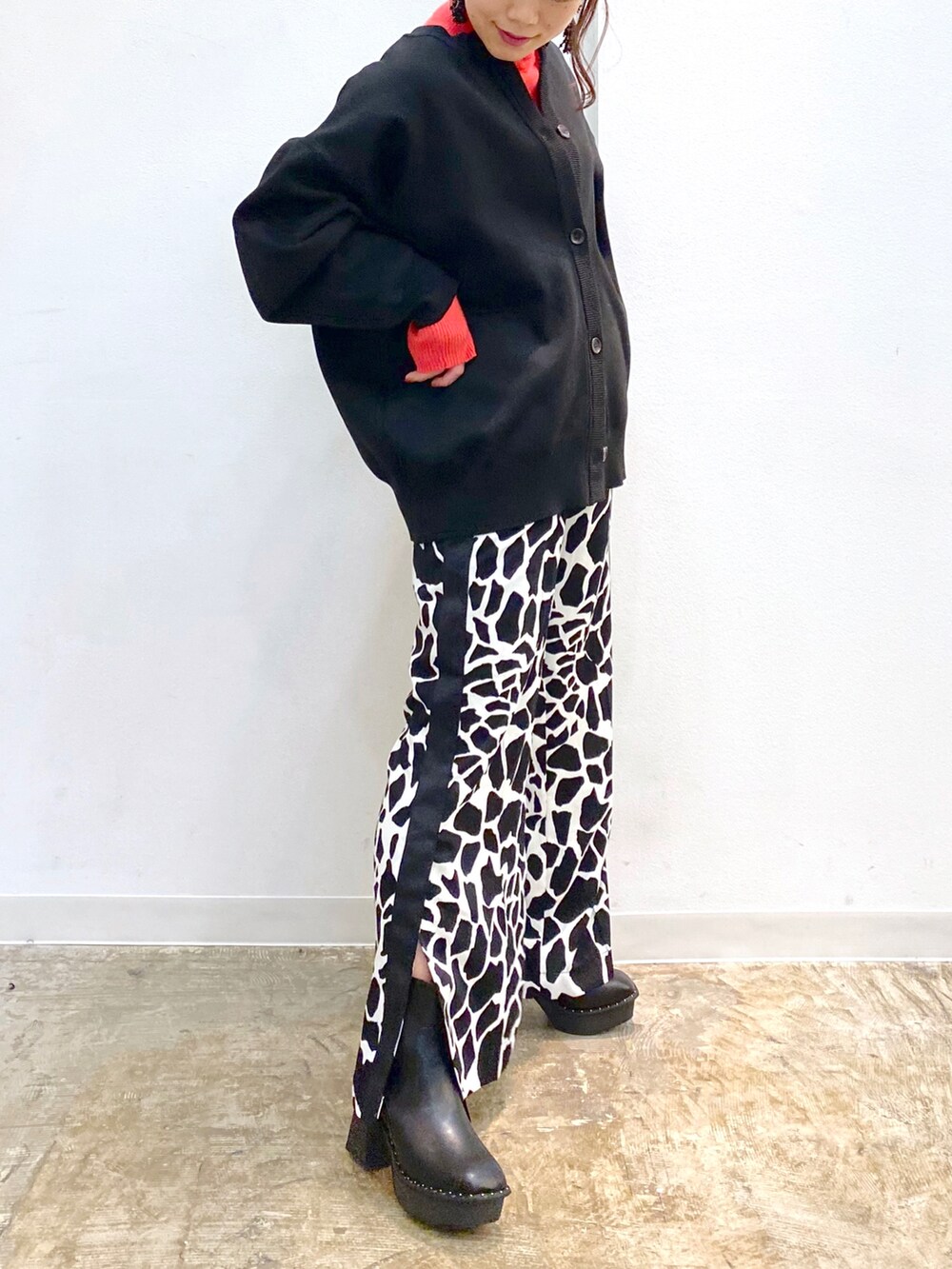 ブラック系のカーディガン/ボレロ、ピンク系のニット/セーター、ブラック系のブーツを着用したレディースの冬コーディネートの3枚目の写真