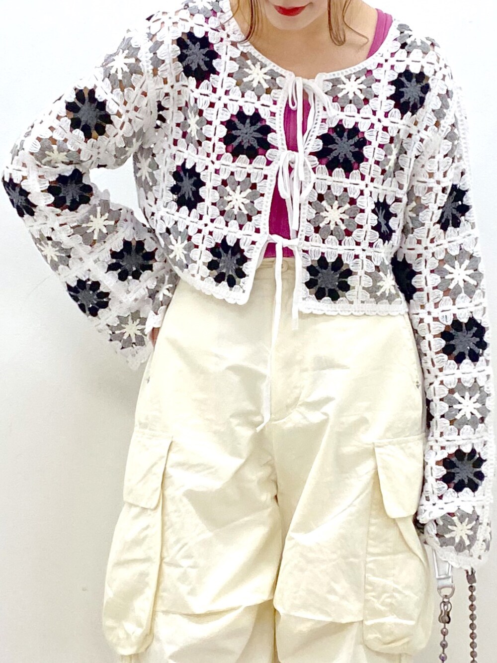 ホワイト系のカーディガン/ボレロ、ピンク系のタンクトップ、ホワイト系のカーゴパンツを着用したレディースの春コーディネートの2枚目の写真