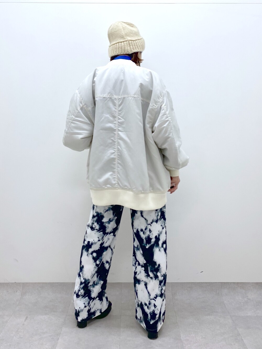 ホワイト系のMA-1、ブラック系のパンツ、ブルー系のトップスを着用したレディースの秋コーディネートの4枚目の写真