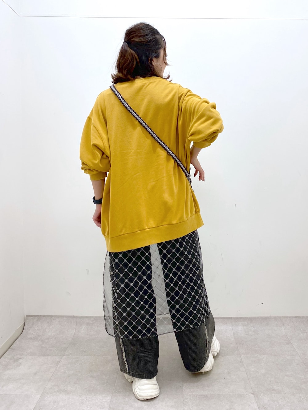 イエロー系のスウェット、ブラック系のデニムパンツ、ホワイト系のスニーカーを着用したレディースの夏コーディネートの5枚目の写真