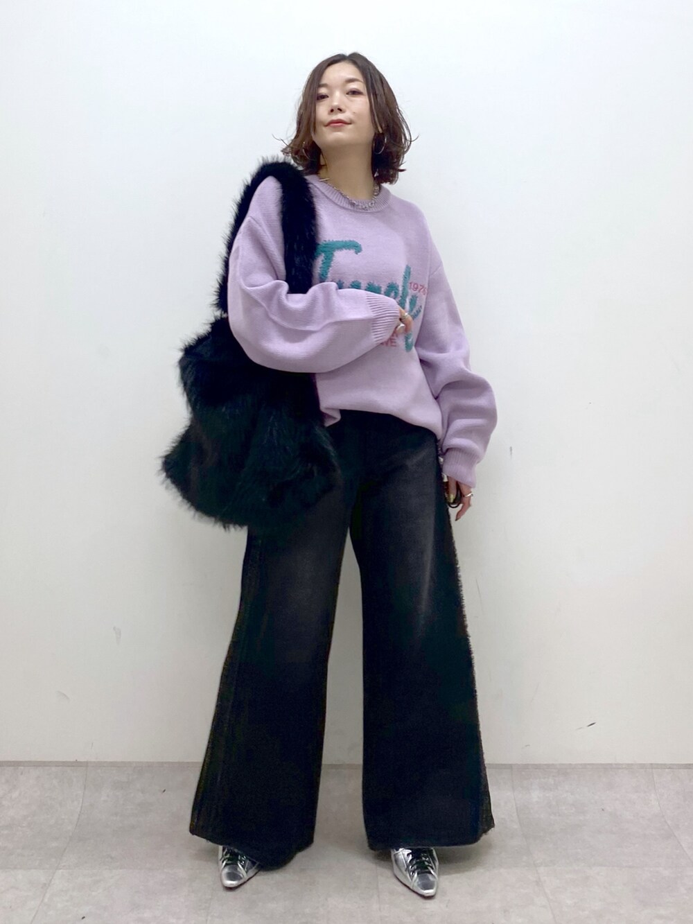 パープル系のニット/セーター、ブラック系のデニムパンツ、シルバー系のパンプスを着用したレディースの秋コーディネートの8枚目の写真