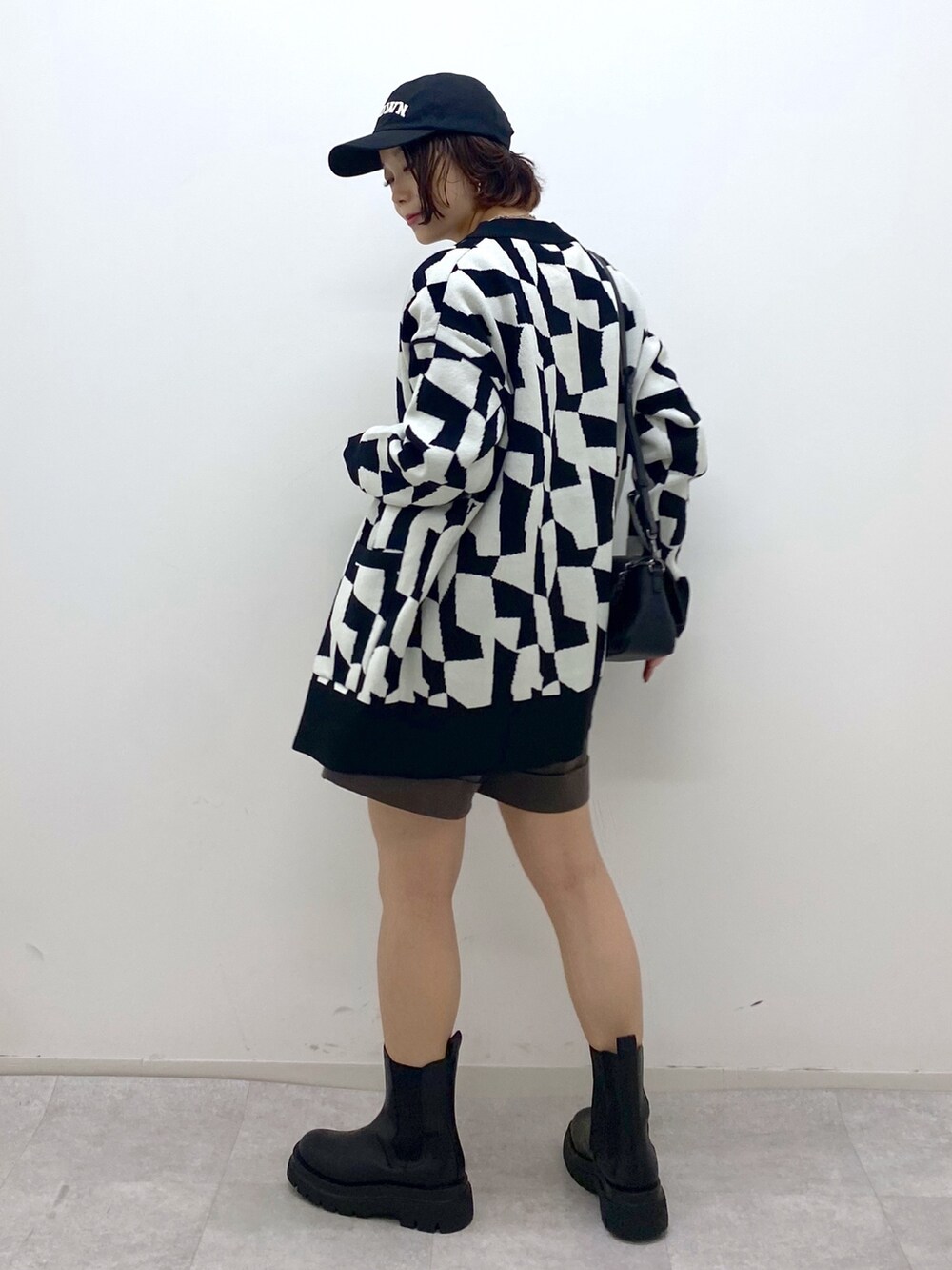 ブラック系のトップス、ブラウン系のパンツ、ホワイト系のTシャツ/カットソーを着用したレディースの秋コーディネートの3枚目の写真