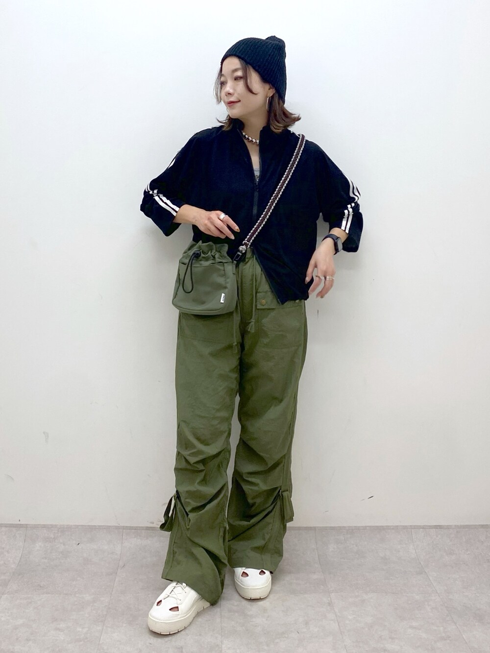 グリーン系のカーゴパンツ、ホワイト系のスニーカー、グリーン系のショルダーバッグを着用したレディースの夏コーディネートの8枚目の写真