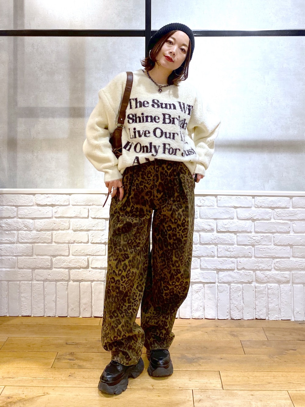 その他のデニムパンツ、ブラウン系のショルダーバッグ、ホワイト系のニット/セーターを着用したレディースの冬コーディネートの4枚目の写真